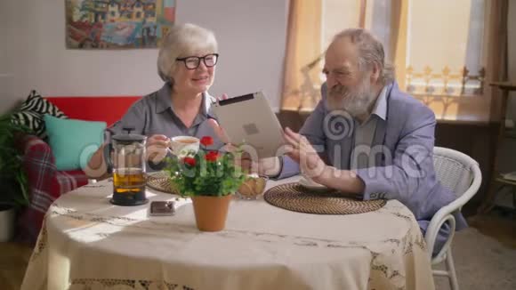 年长的祖父母在平板电脑上和家人交谈视频的预览图