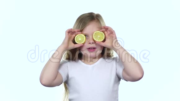孩子们用柠檬闭上眼睛表现出不同的情绪舔它和呱呱叫白色背景慢动作视频的预览图