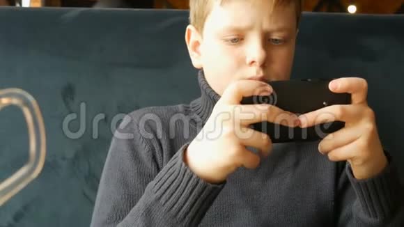少年在黑色智能手机上玩游戏视频的预览图