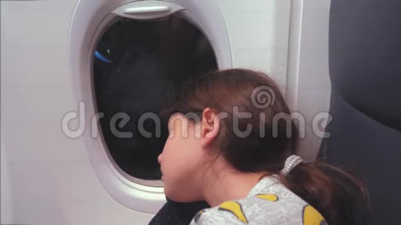 航空飞机概念坐在窗边的小女孩睡在飞机上生活方式之夜的飞行视频的预览图