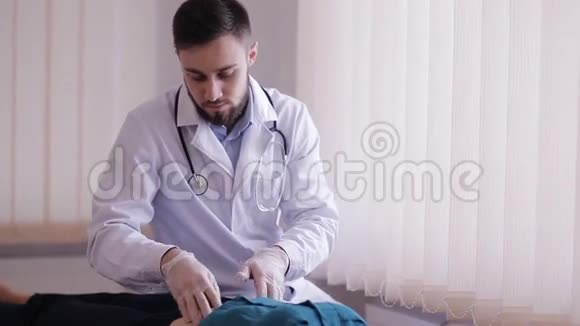 男医生对病人的腹部进行触诊那个女孩躺在医生办公室沙发上视频的预览图
