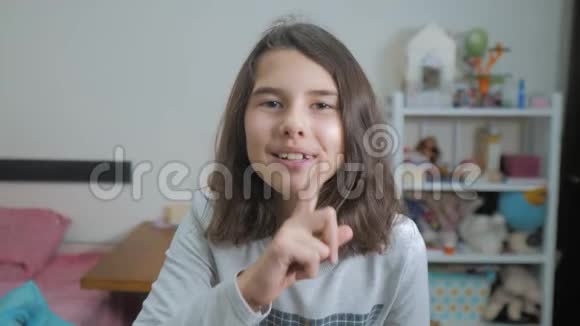 小少女手势手指安静慢动作录像女孩伸出手指到嘴唇说嘘青少年视频的预览图