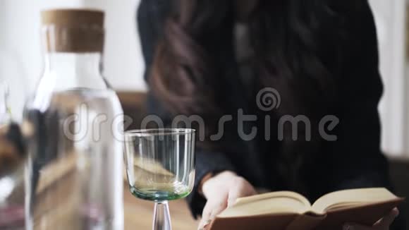 年轻的亚洲女人看书喝水手拿视频的预览图