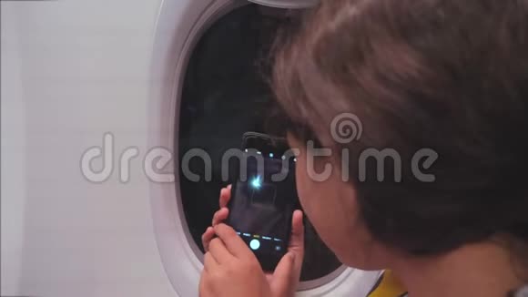 航空飞机概念年轻女孩正坐飞机在下面的智能手机之夜城市拍照视频的预览图