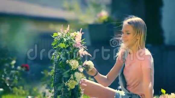 夏日阳光灿烂的节日回忆金发微笑的女孩用粉色和白色的花朵组成了一个温柔的花朵视频的预览图