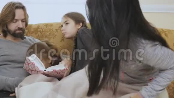 幸福的一家人一起在沙发上看书放松视频的预览图