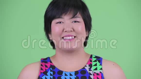 一位年轻体重超重的亚洲女性微笑着准备参加聚会视频的预览图