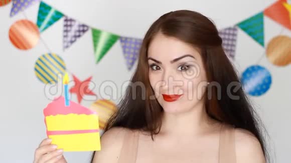 生日快乐有趣的女孩微笑着手里拿着蛋糕吹出一支纸烛视频的预览图