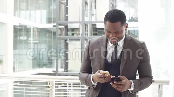 非裔美国商人在智能手机上阅读电子邮件并发短信回答慢动作视频的预览图