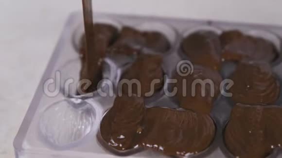 做自制的普拉林糖果倒巧克力特写镜头视频的预览图