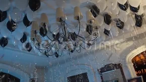在一个大吊灯周围用充气的黑白球装饰了餐厅的天花板视频的预览图