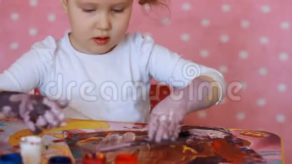 有趣的孩子用油漆画他的手小艺术家小女孩画艺术视频的预览图