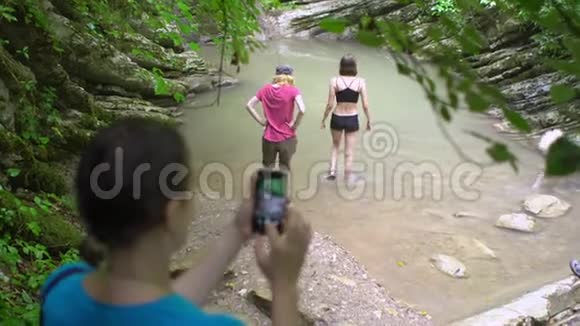 在绿色热带森林中用智能手机拍摄照片和视频的女人视频的预览图