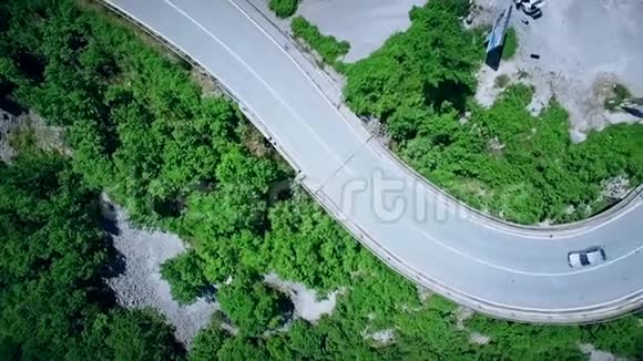 汽车经过的弯曲蜿蜒的道路的鸟瞰图山区公路视频的预览图