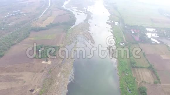 在小农耕社区村里巨大的安静阴暗的浅水河水流淌着低空飞行无人机空中飞行视频的预览图