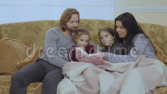 幸福的家庭在沙发上一起读童话故事视频的预览图