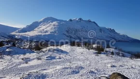 雄伟的山谷峰顶洁白的白雪和蓝天北极圈挪威北部视频的预览图