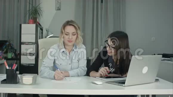 金发的办公室女性画素描而黑发的同事提出想法视频的预览图