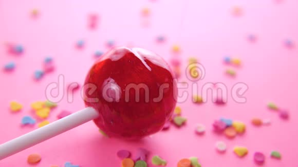 粉色背景上粉色圆形棒棒糖特写视频的预览图