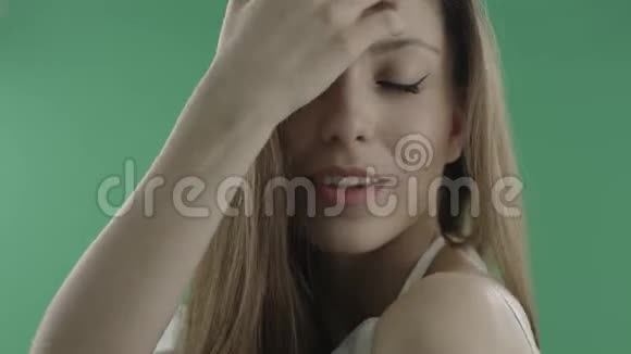 一位年轻迷人的女士头发松松的绿色的背景视频的预览图