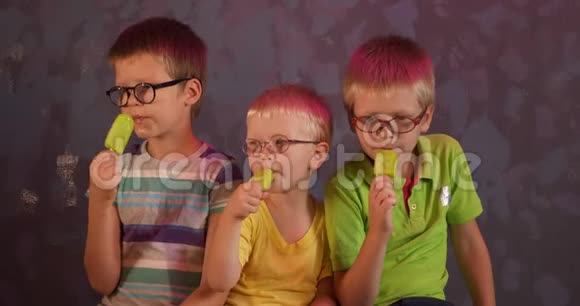 有趣的孩子兄弟戴眼镜吃绿色开心果冰淇淋的棍子儿童为视障儿童上学视频的预览图