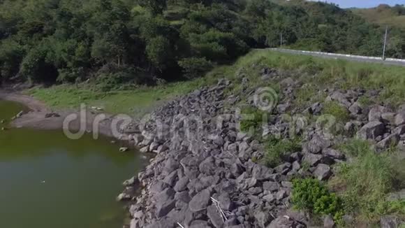 空中无人机在水电站大坝岩石挡墙上的公路射击视频的预览图