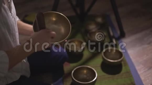 专业男青铜藏唱碗演奏者华丽的声音音乐坐在地板上瑜伽冥想视频的预览图