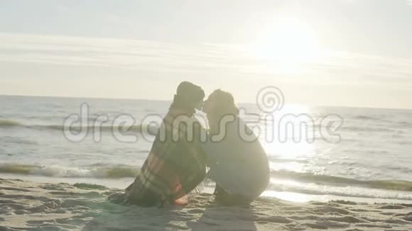 可爱的小男孩和他年轻的母亲一起在海边度过时光儿子在阳光明媚的海滩亲吻女人视频的预览图