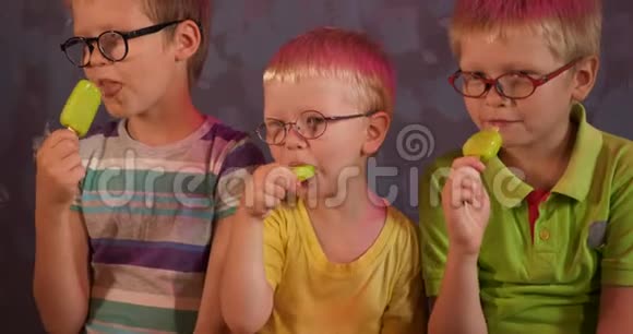 有趣的孩子兄弟戴眼镜吃绿色开心果冰淇淋的棍子儿童为视障儿童上学视频的预览图