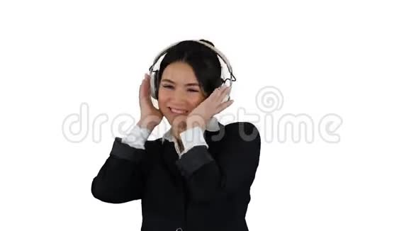 年轻的商务女性听着耳机里的音乐在白色背景下跳舞视频的预览图
