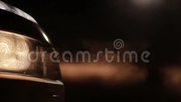 明亮的汽车前灯在夜晚的尘埃中视频的预览图