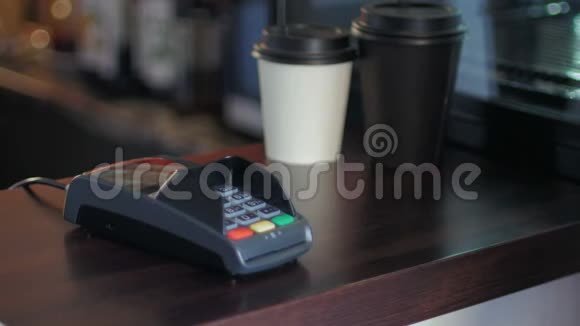 咖啡馆里的年轻人正在使用智能手机和终端来支付价格视频的预览图