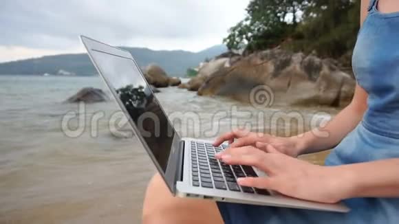 慢动作作家在海边的笔记本电脑上写小说的女性视频的预览图