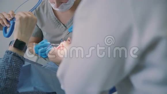 计划去看牙医坐在牙科椅上拿着镜子的妇女医生和牙科护士在用牙齿工作视频的预览图