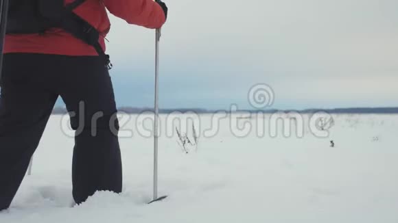 三个徒步旅行者带着徒步旅行杆背包和雪鞋的后景带背包的快乐徒步旅行者小组视频的预览图