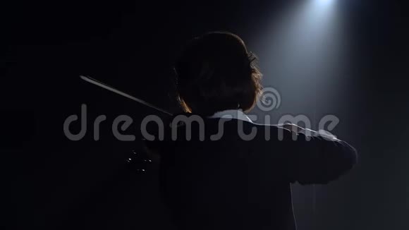 女孩们站在后面在黑暗的房间里演奏小提琴黑烟背景视频的预览图