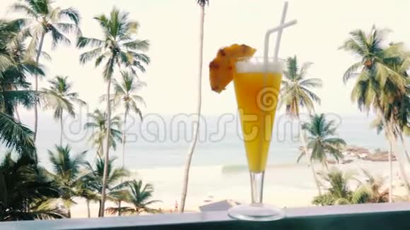 在热带海滩背景下的一杯无酒精菠萝鸡尾酒视频的预览图