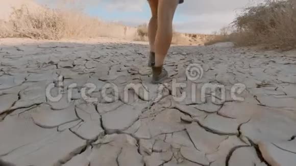 穿皮靴的女人在干燥的土壤中行走视频的预览图