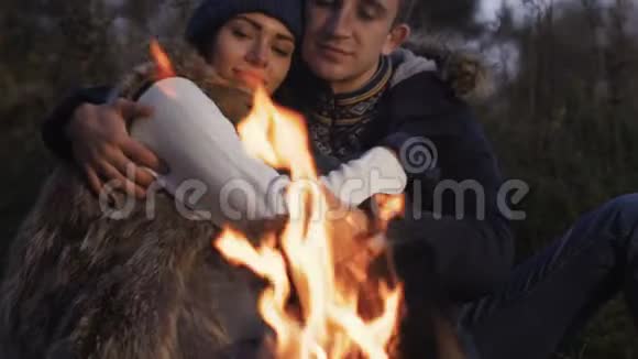 浪漫的情侣在篝火旁平静地休息慢慢地视频的预览图