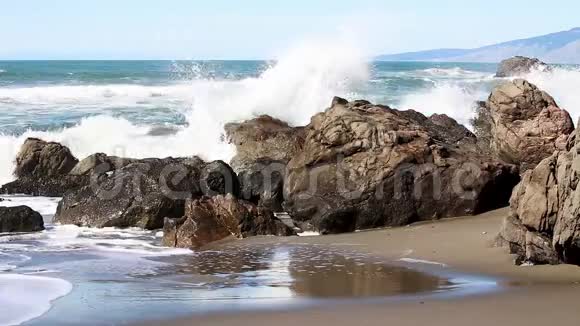 海浪冲击着沙滩上的岩石视频的预览图