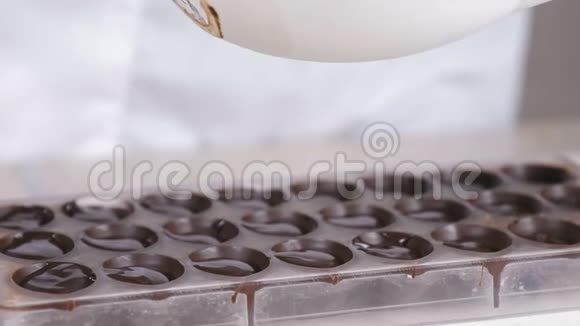 做自制的普拉林糖果倒巧克力特写镜头视频的预览图