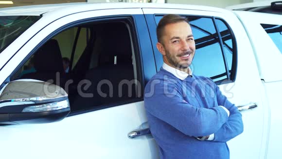 一个快乐的人靠在他的新车上视频的预览图