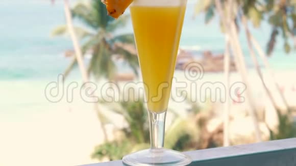 在热带海滩背景下的一杯无酒精菠萝鸡尾酒视频的预览图