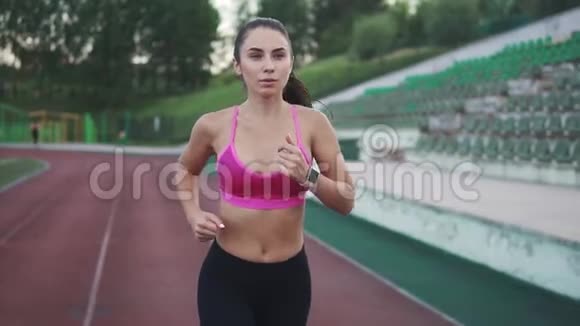 漂亮的跑步运动员在体育场的跑道上慢跑慢动作视频的预览图