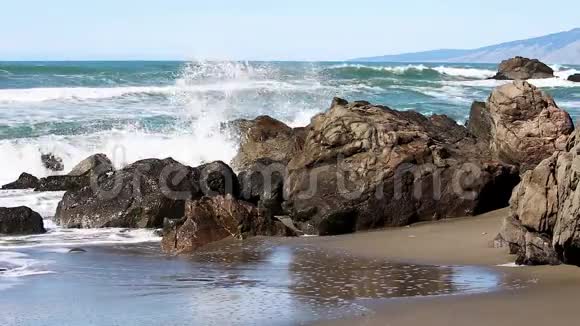 海浪冲击着沙滩上的岩石视频的预览图