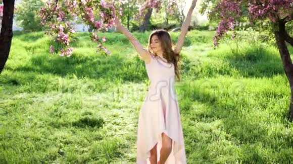 一个带着花束的女人走在开花的树间视频的预览图