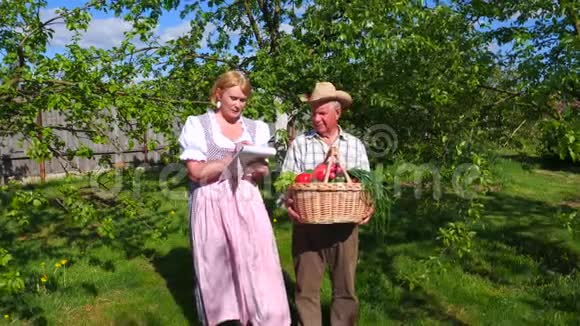 老人拿着一篮子成熟的蔬菜收集一个女人检查它们视频的预览图