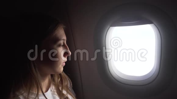 女孩坐在飞机窗口看着外面视频的预览图