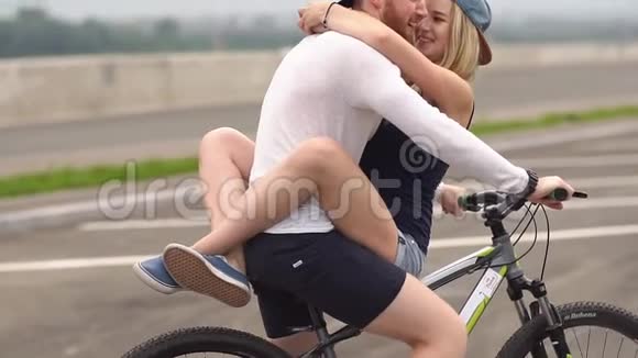 浪漫的年轻夫妇在小镇骑自行车慢动作视频的预览图