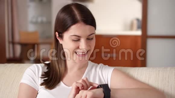 家里的女人在智能手表上发短信漂亮的年轻女性专业人士视频的预览图